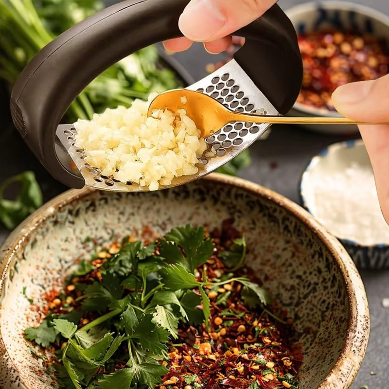 Garlic press rocker, crusher, mincer tool stainless steel with a Garlic Peeler, spatula, and Brush extract more Garlic Paste. The Garlic Mincer Tool Squeezes, Extracts, Crushes